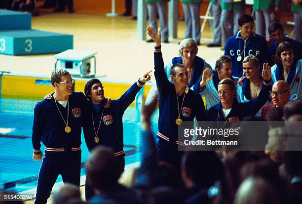 Olympic men's 4X200 meter relay team waving to the crowd, and wearing their gold medals after they won the race. They are, left to right: John...