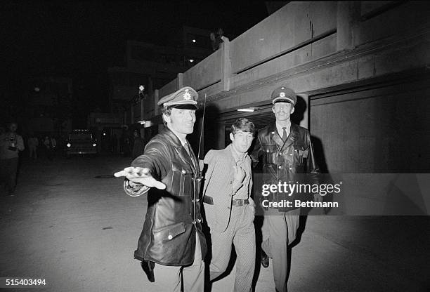 Munich: Two Munich policemen ward off a photographer as they escort an unidentified prisoner away from the Israeli team quarters at the Olympic...