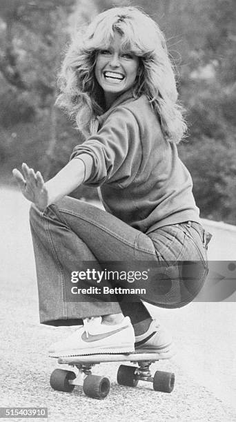 Actress Farrah Fawcett, wearing jeans, sweatshirt and Nike athletic shoes, practices skateboarding for an episode of Charlie's Angels.