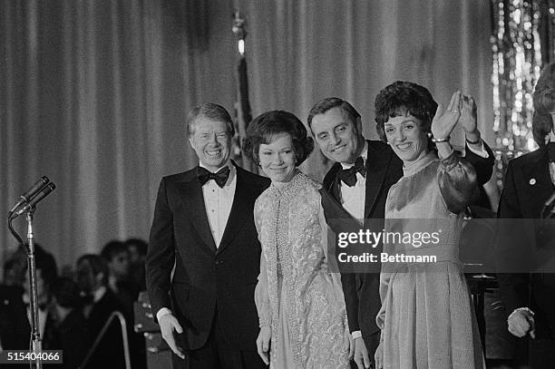 President Jimmy Carter, First Lady Rosalynn Carter, Vice President Walter Mondale, and Joan Mondale look down as the crowds at one of the parties in...