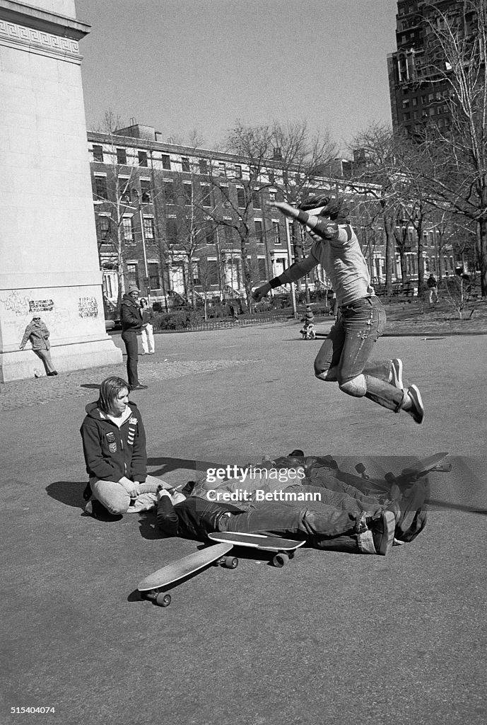 Skateboarder Jumping over People onto Skateboard