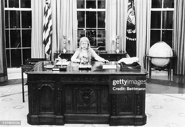 Amy Carter sits at the president's desk in the Oval Office in a picture taken by her brother Jeff.