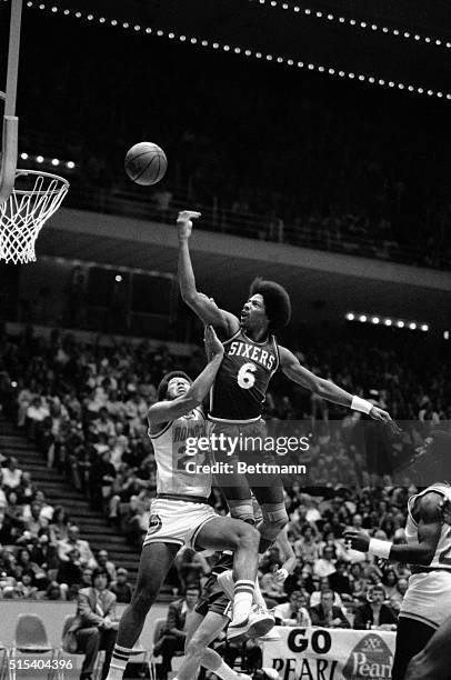 Philadelphia 76ers' Julius "Dr. J." Erving goes high over Houston Rockets defender John Johnson to score in the first period of the 10/27 game.