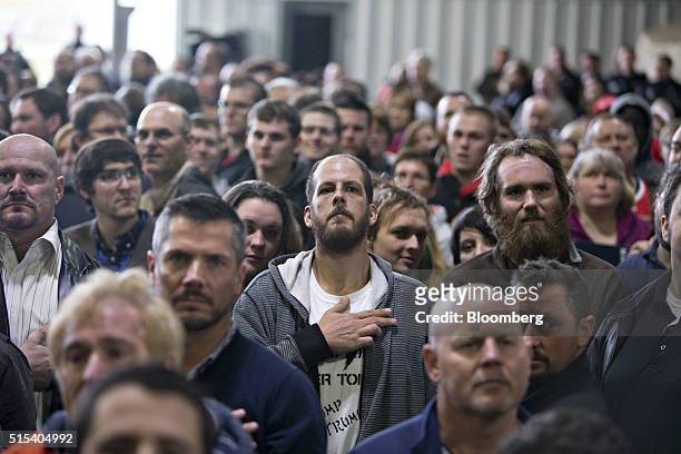 Attendees listen to the U.S. National Anthem at the start of a campaign event for Donald Trump, president and chief executive of Trump Organization...