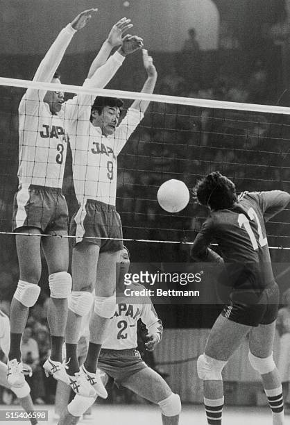 Montreal: Japanese volleyball players go up into the air to smash the ball at Italy's Marco Negri , in their group B match here 7/20. L-R, the...