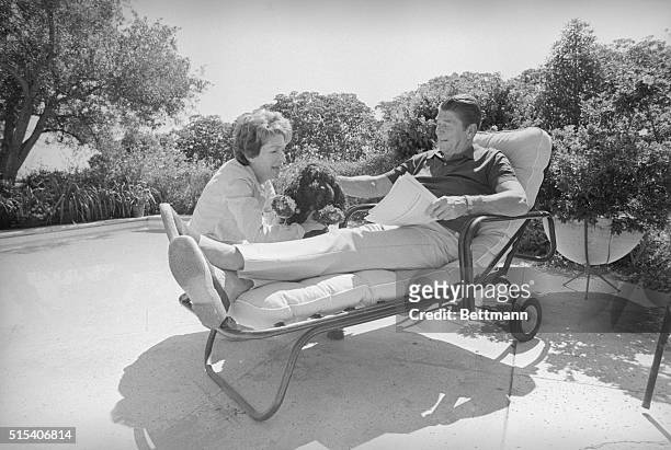 Pacific Palisades, Calif.: Ronald Reagan relaxes at poolside along with his wife, Nancy and the pet poodle named Muffin after returning home from the...