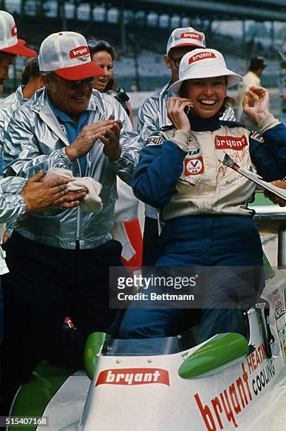 Janet Guthrie of Iowa City, glows with happiness as pit crew applauds her after she became first woman to qualify for the Indianapolis 500 auto race,...