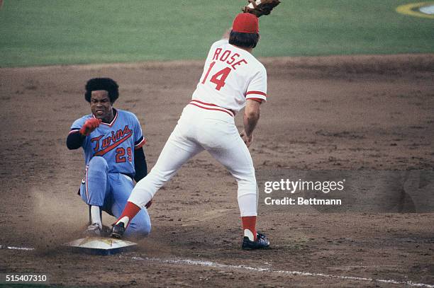 American League's Rod Carew slides into his second triple of the day as Cincinnati Reds' Pete Rose waits for the throw.