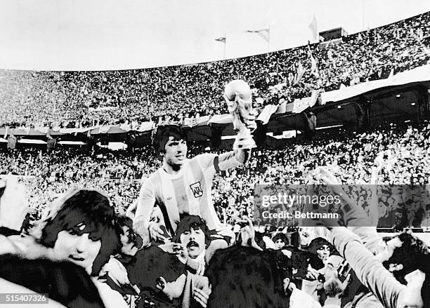 World Cup Final. Argentine team captain Daniel Passarella is carried on shoulders of fans as he shows FIFA World Cup his team won by defeating...