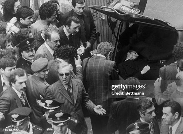 In downtown Rome, May 9th, policemen and others are gathered around the car containing the body of Aldo Moro, former Italian Premier. Moro had been...