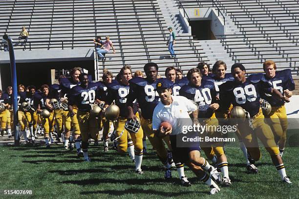 South Bend, Ind.: Notre Dame coach Dan Devine leads his charges onto the field as the Fighting Irish launch their 1977 campaign. Identifiable are:...