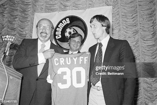 New York: Ahmet Ertegun , President of the New York Cosmos and Johan Cruyff, Holland's 1974 World Cup team captain, hold the uniform Cruyff will wear...