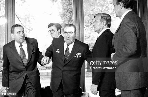 Soviet Foreign Minister Andrei Gromyko, left, and West German Chancellor Helmut Schmidt help Soviet President Leonid Brezhnev to his feet after...