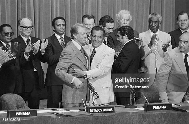 President Carter smiles as Panama's military leader General Omar Torrijos embraces him, after the two leaders signed the ratified Panama Canal...