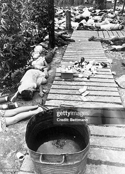 Bodies lay strewn around a vat containing a beverage laced with cyanide at the Jonestown commune of the People's Temple in Guyana. This mass suicide...