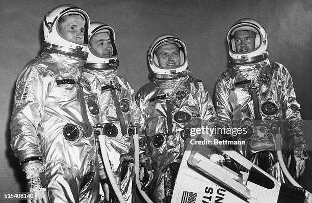 Houston, TX-The primary and backup astronaut crews for the second manned Gemini flight next spring pose in their space suits with a model of the...