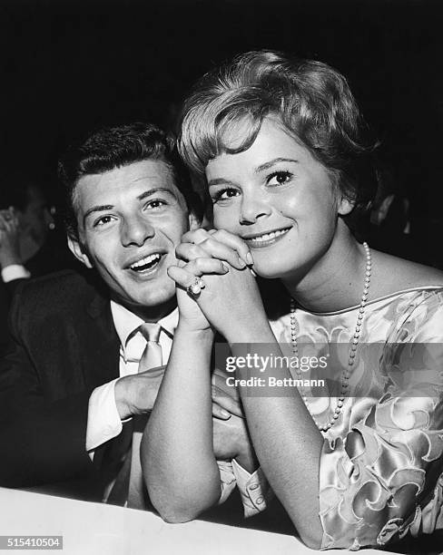 American teen idol Frankie Avalon sitting with Italian actress Leticia Roman at an event, circa 1960.