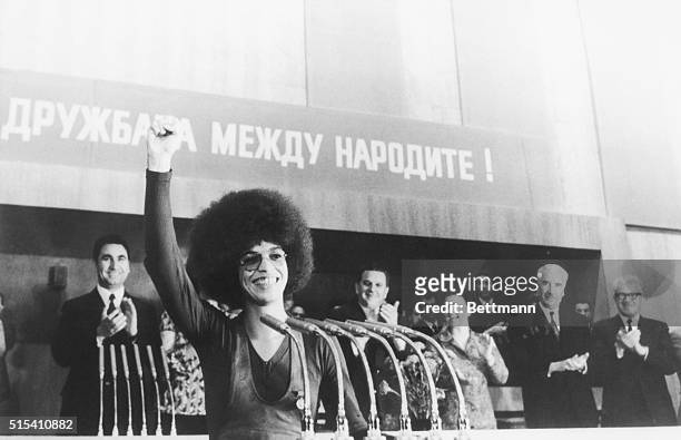 Showing a Black Power salute and that now familiar gap-toothed smile. Black American militant, Angela Davis, earns warm applause from her audience in...