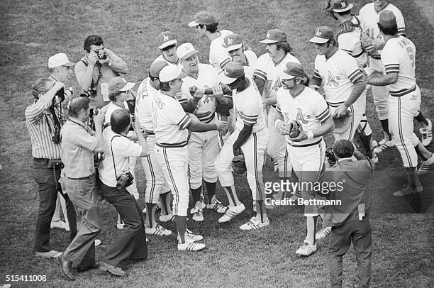 Jubilant after winning their 2nd straight game in a row in the American League playoffs, Oakland Athletics players swarm on to the field after...