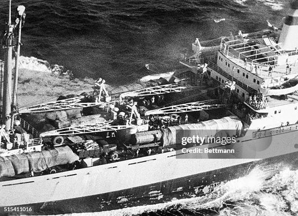 Off Puerto Rico- Aerial close-up of the Soviet freighter Anosov shows a crew member, stripped to the waist, on a missile carrier, rolling back part...