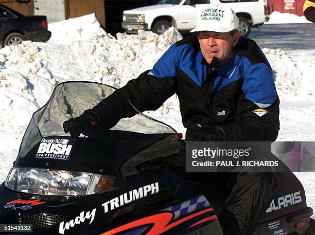 Presidential hopeful Texas Governor George W. Bush drives a demonstrator model snowmobile at a dealership's test course 28 January 2000 in Hooksett,...