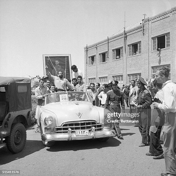 Tehran, Iran- A huge portrait of the Shah of Iran is carried through the streets of Tehran by followers of the 33-year-old monarch, as he makes his...