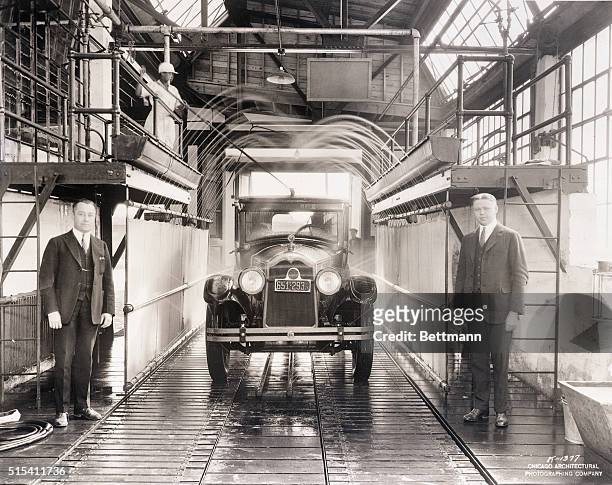 Chicago, IL-: An automobile passing through the shower bath at the world's first car wash in Chicago. Note how the top is thoroughly washed by the...