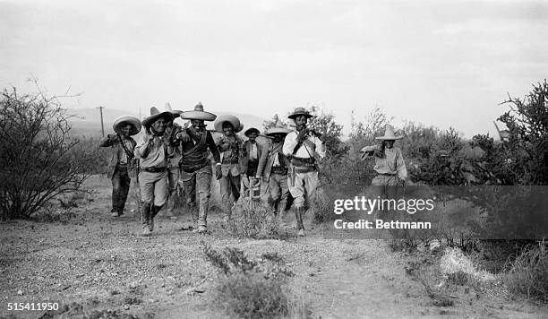Mexico: Mexican Revolution of 1913. Photo shows Pancho Villa's troops walking through bushy terrain.