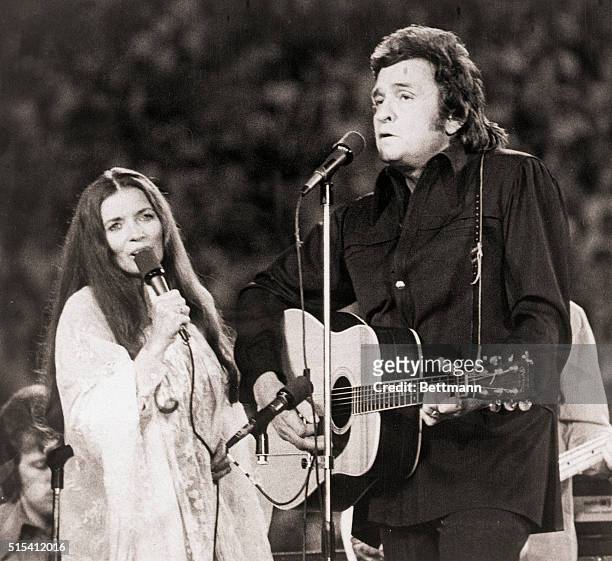 Johnny Cash , and wife June Carter performing at Mississippi Memorial Stadium.