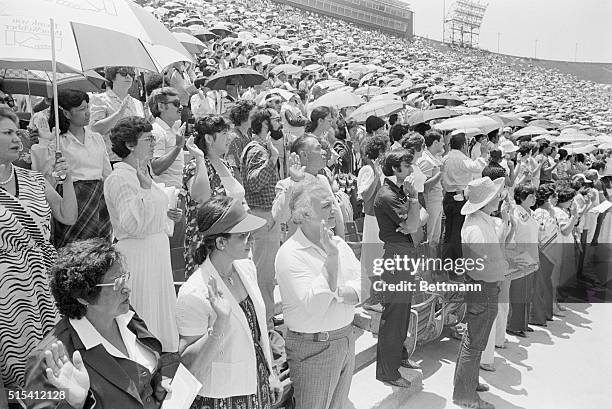Los Angeles, California- 10,000 immigrants, many holding umbrellas in their left hands as they take thieir American citizenship oath, are sworn in as...
