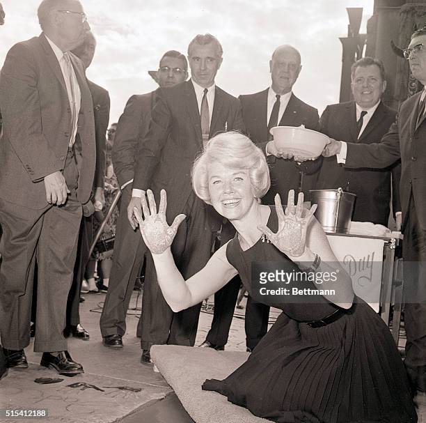 Hollywood, California- Singer and actress Doris Day, assisted by film executives John Tartaglia and Roy Evans , holds up her palms after pushing her...