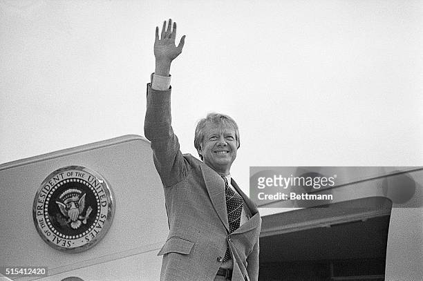 Washington, DC-: President Carter, shown waist-up, waves as he boards a helicopter on the White House lawn to fly to Camp David, Maryland, where he...