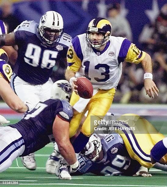 St. Louis Rams quarterback Kurt Warner scrambles in an attempt to avoid the rush of the Tennessee Titans defense during first half action in Super...