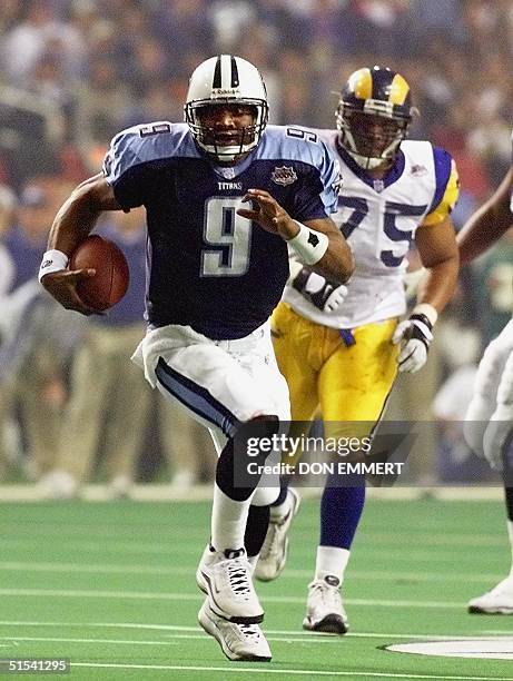 Tennessee Titans quarterback Steve McNair takes off on a run as the St. Louis Rams defensive tackle D'Marco Farr persues during second half action in...