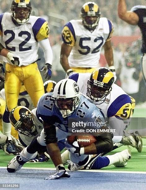Tennessee Titans running back Eddie George dives into the end zone for a touchdown as St. Louis Rams linebacker Lorenzo Styles attempts to stop him...