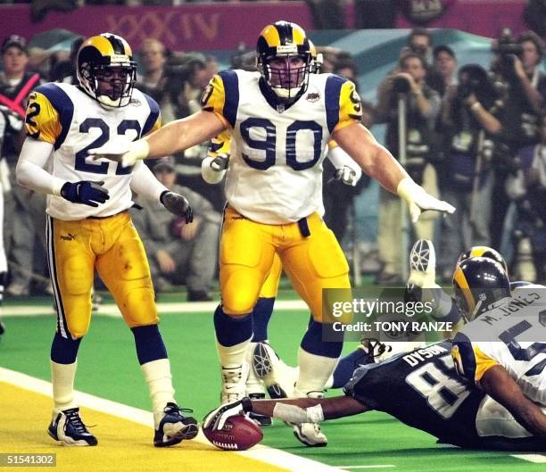 St. Louis Rams defensive player Jeff Zgonina signals no touchdown as Tennessee Titans wide receiver Kevin Dyson stretches the ball over the goal line...