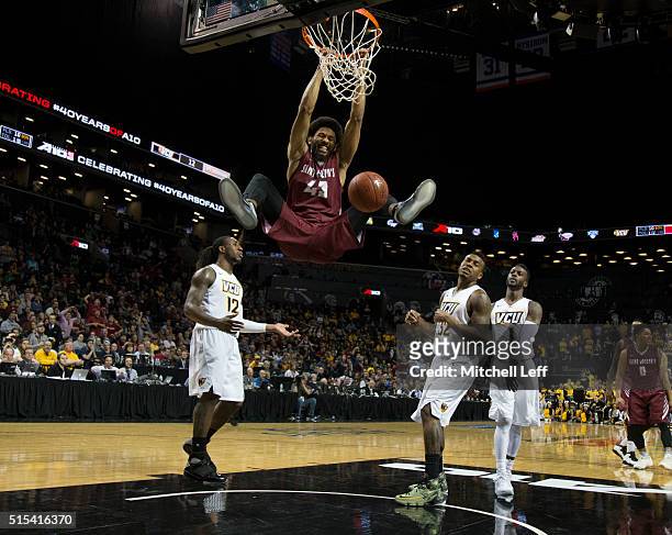 DeAndre Bembry of the Saint Joseph's Hawks dunks the ball against Mo Alie-Cox, Melvin Johnson, and JeQuan Lewis of the Virginia Commonwealth Rams in...