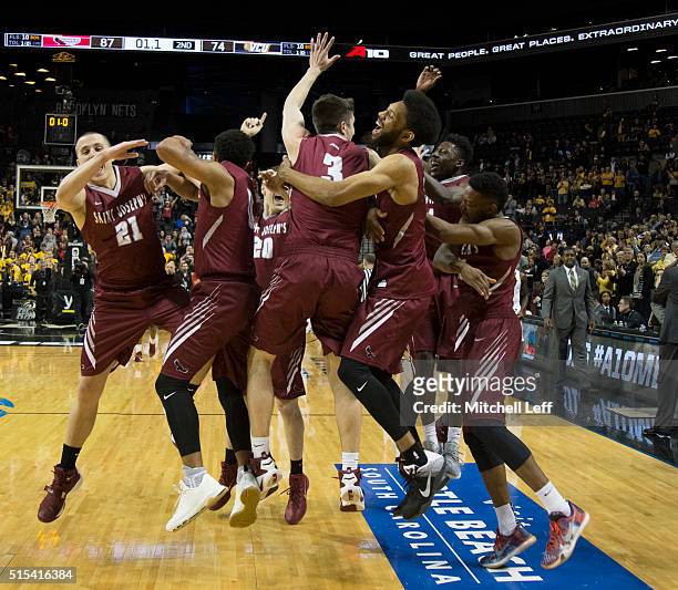 Kyle Thompson, Lamarr Kimble, Mike Booth, DeAndre Bembry, and the rest of the Saint Joseph's Hawks celebrate after the game against the Virginia...