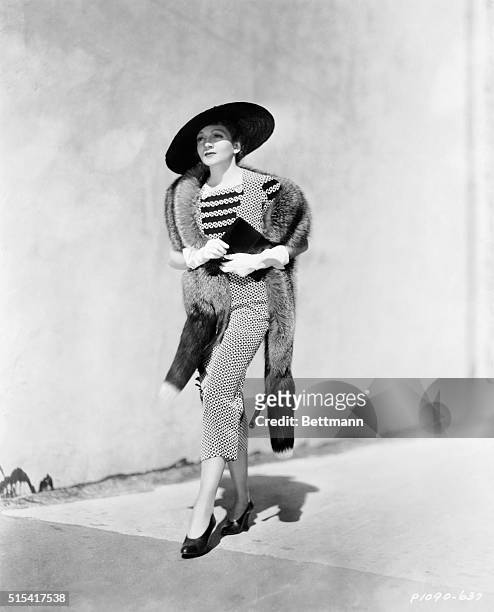 Topping all colors is the classic combination of black and white for spring and summer. Here is Claudette Colbert, Paramount star, dressed in a...