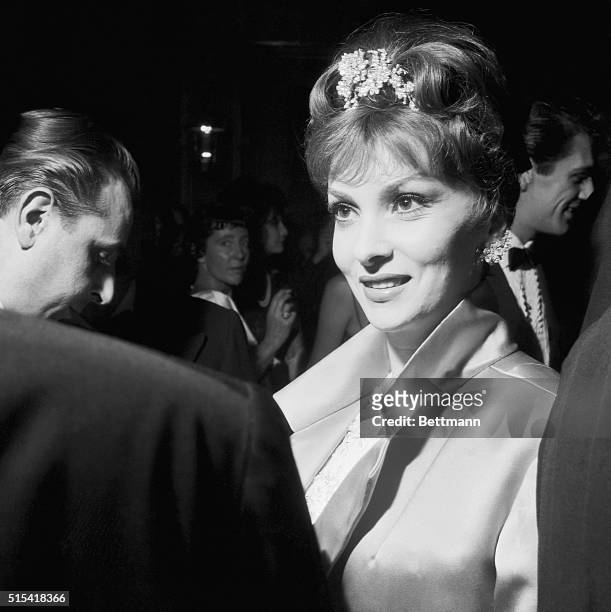 Lovely Gina Lollobrigida enjoys an animated conversation at the star-studded party which actress Elizabeth Taylor gave at the Grand Hotel in Rome....