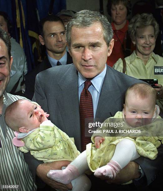 Republican presidential hopeful Texas Governor George W. Bush holds seven-month-old twins Reagan and Riley Ammons of Columbia, South Carolina, after...