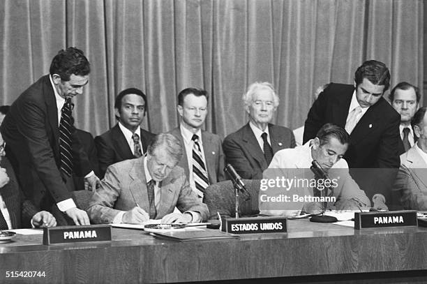 Panama City, Panama- President Carter and Gen. Omar Torrijos of Panama sign the ratified Panama Canal treaties 6/16. Sitting in rear are LtoR: U.S....