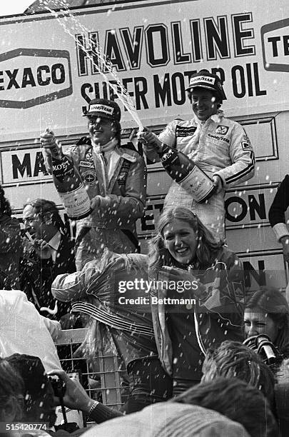 Mario Andretti and his Swedish teammate, Ronnie Peterson, spray onlookers with champagne form the victory podium at the Belgium Grand Prix on May...