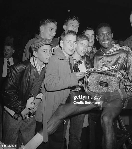 Fans seeing autographs crown around Bill Russell of San Francisco after he was awarded trophies as the Most Valuable Player following the college...