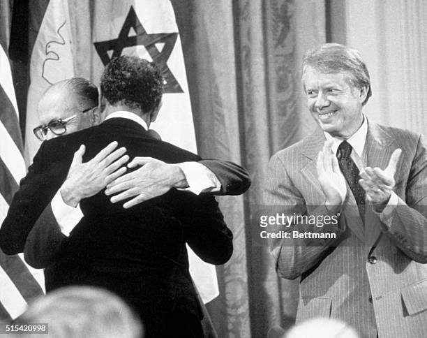 Washington, DC: - With Jimmy Carter applauding, Israeli Prime Minister Menachem Begin and Egyptian President Anwar Sadat embrace in the East Room of...