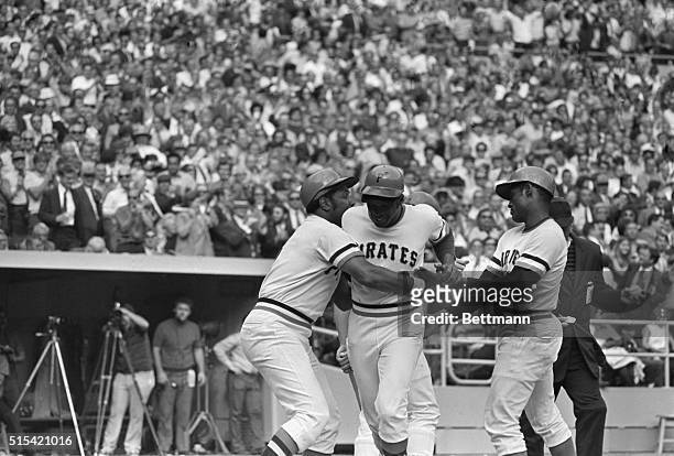 Pittsburgh Pirates Al Oliver is grabbed by teammates Willie Stargell and Roberto Clemente after his three-run-homer which gave the Pirates a 9-5...