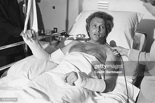 Stunt performer Evel Knievel gives interviews from his hospital bed after suffering a fractured right arm and left collarbone when he lost control of...