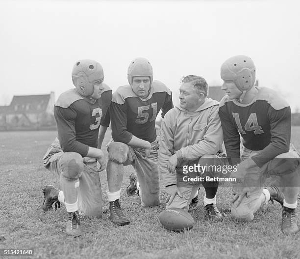 Green Bay Packer coach Curly Lambeau goes over plans with running back Tony Canadeo , quarterback Irv Comp , and tight end Don Huston for Sunday's...
