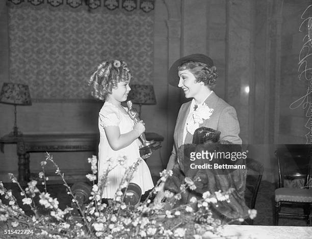 Actress Shirley Temple presents the Oscar for Best Actress to Claudette Colbert for her role in It Happened One Night.