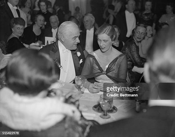 Mrs. John Boettiger, the former Anna Roosevelt Dall, daughter of the President, is shown chatting with Raymond Baker, former Director of the Mint, at...